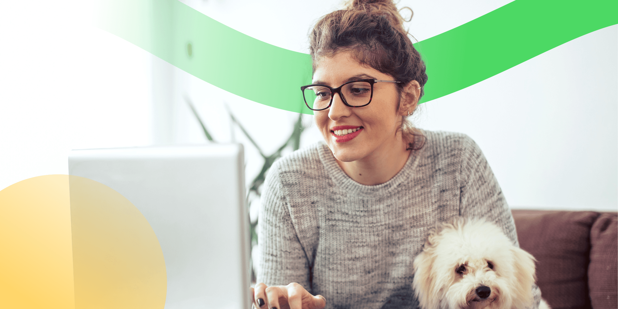 A woman is sitting at her laptop wearing glasses and holding her dog while creating internal resources for neurodiversity celebration week.